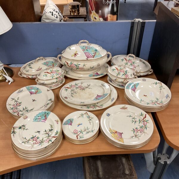 Stack of antique Victorian china plates with floral designs.