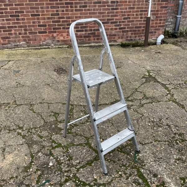 Silver three-step aluminium ladder for household use.