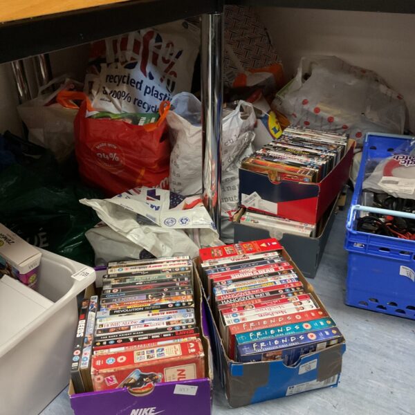 Large assortment of DVDs in a plastic container.