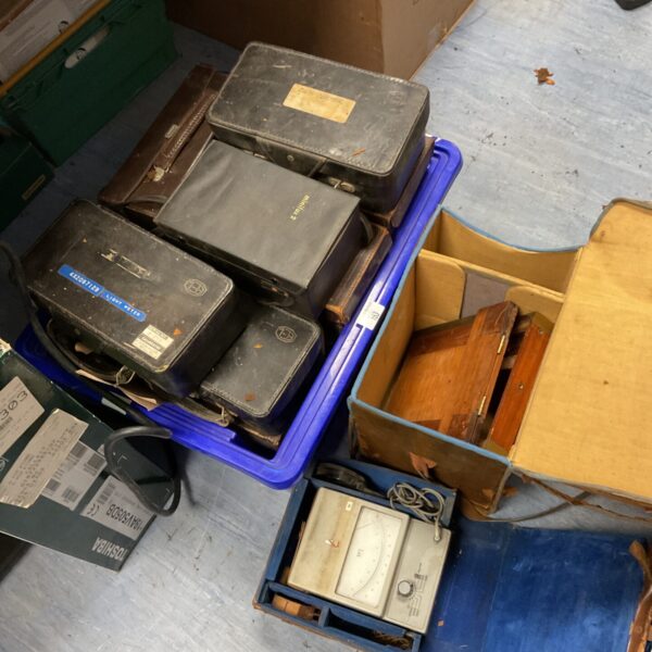 Vintage test meters in a weathered carrying case, electrical instruments.
