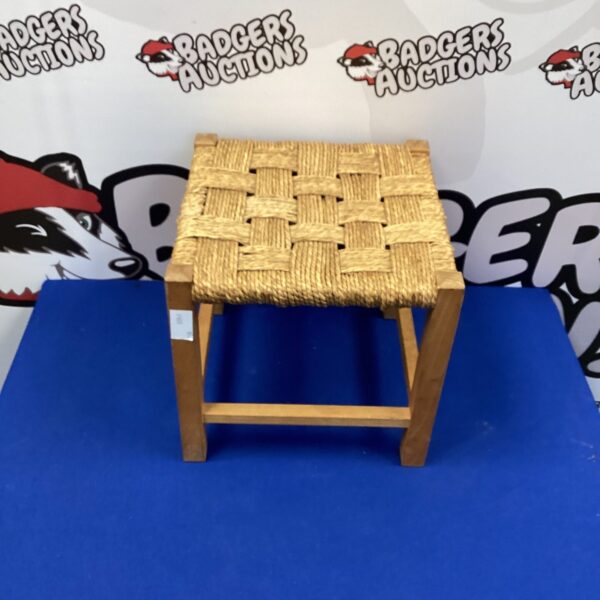 Vintage foot stool with woven rope seat and wooden frame.