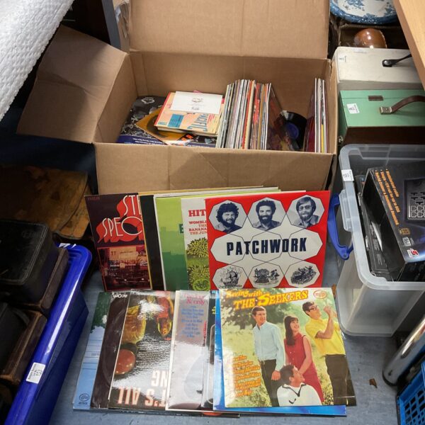 Large lot of used vinyl records in a cardboard box.