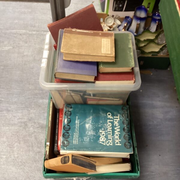 Stack of vintage reference books in a storage container.