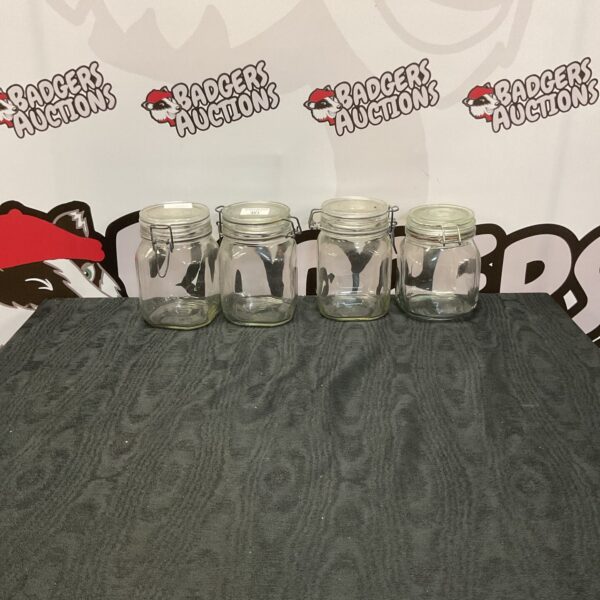 Lot of four reusable glass jars for kitchen storage.