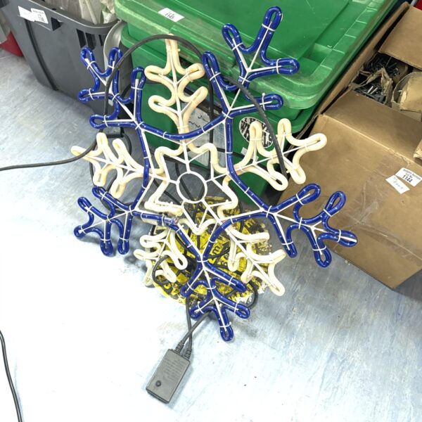Illuminated Christmas snowflake light decoration for outdoor holiday displays.