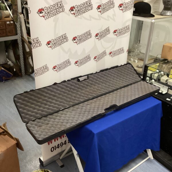 Black Doskocil padded gun case on a blue surface.