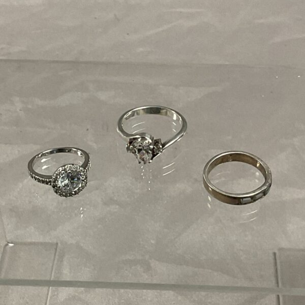 Silver stone set rings in sizes K, N, and S.