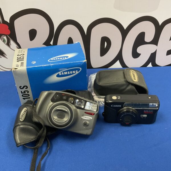 Vintage Canon Sure Shot and Samsung Zoom 105s cameras on display.