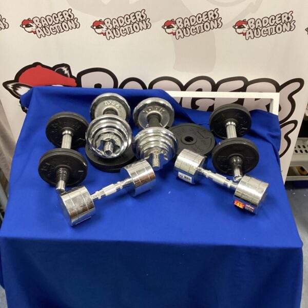 Mixed lot of dumbbells and weight plates for home fitness.