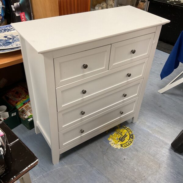 White chest of drawers with two over three drawer configuration.