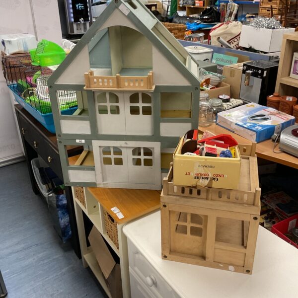 Large wooden dolls house with multiple rooms and pitched roof.