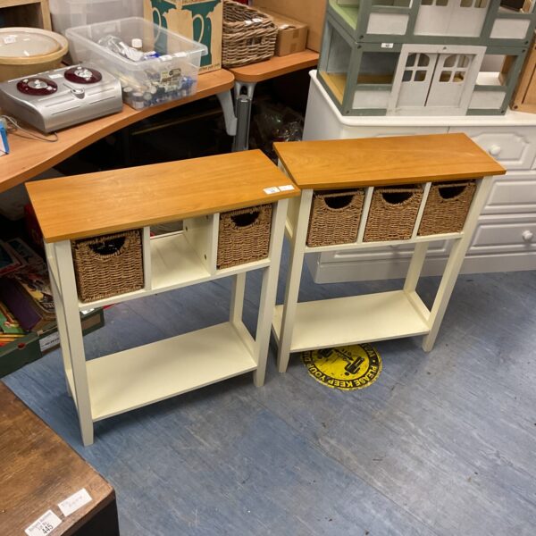 Pair of white storage tables with woven basket drawers for home storage.