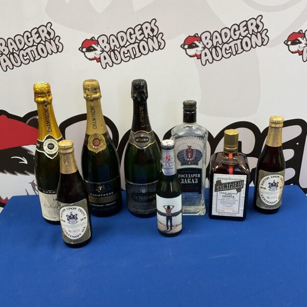 Mixed alcohol lot featuring Devnauroy Champagne and vodka bottles.