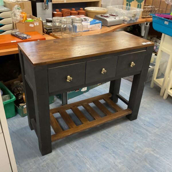 Vintage wooden console table with three drawers and brass knobs.
