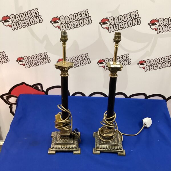 Pair of vintage brass Corinthian column lamps on display.