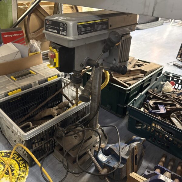 Side view of a Coltech pillar drill with plastic storage containers.