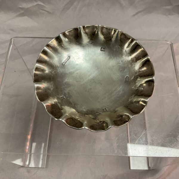 Hallmarked sterling silver pin dish with a crimped edge.