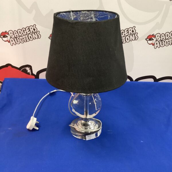 Elegant chrome and glass table lamp with black shade.