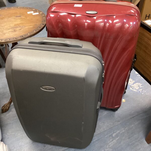 Dark grey Samsonite rolling suitcase with wheels, ideal for travel.