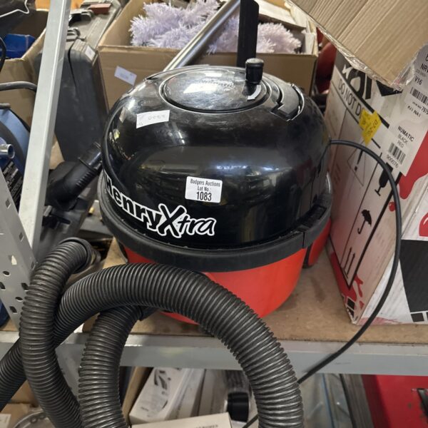 Red Numatic Henry Hoover with extension pole, a powerful vacuum cleaner.