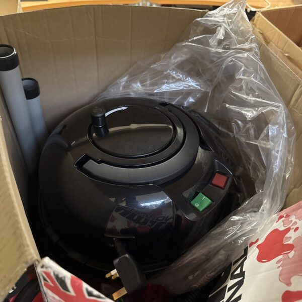 Red Numatic Henry hoover in original box, vintage cleaning appliance.