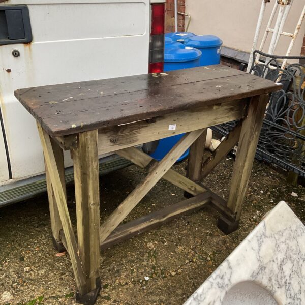 Rustic vintage workbench with worn wood surface and cross bracing.