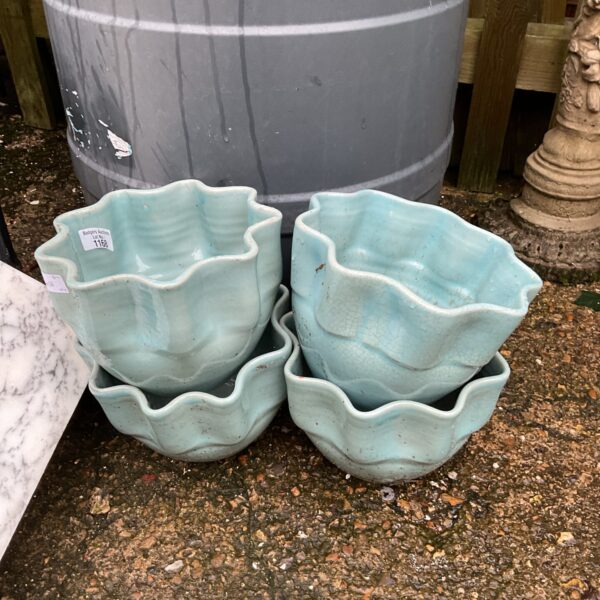 Set of four vibrant turquoise ruffle edge garden pots.