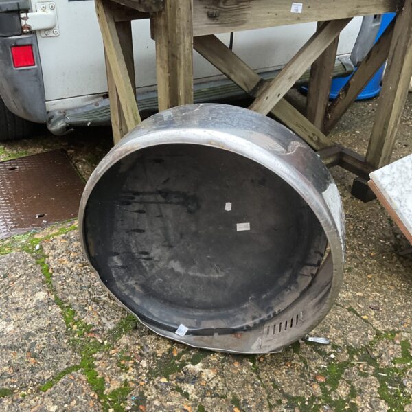 Polished stainless steel wheel cover for vehicle restoration.