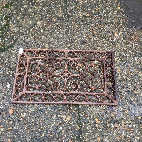 Ornate vintage metal door mat with floral design.