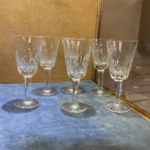 Set of six Waterford Crystal sherry glasses on a blue surface.