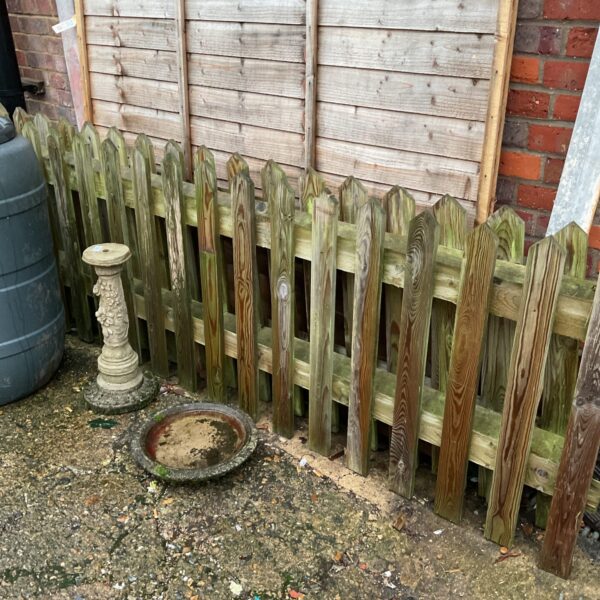 Reclaimed wooden picket fencing in a garden setting.