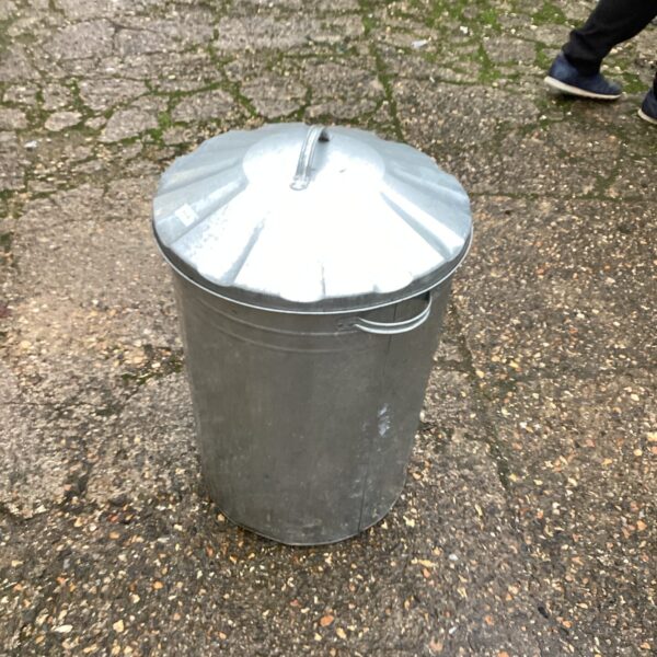 Vintage galvanised garden bin with handles, showing signs of wear.