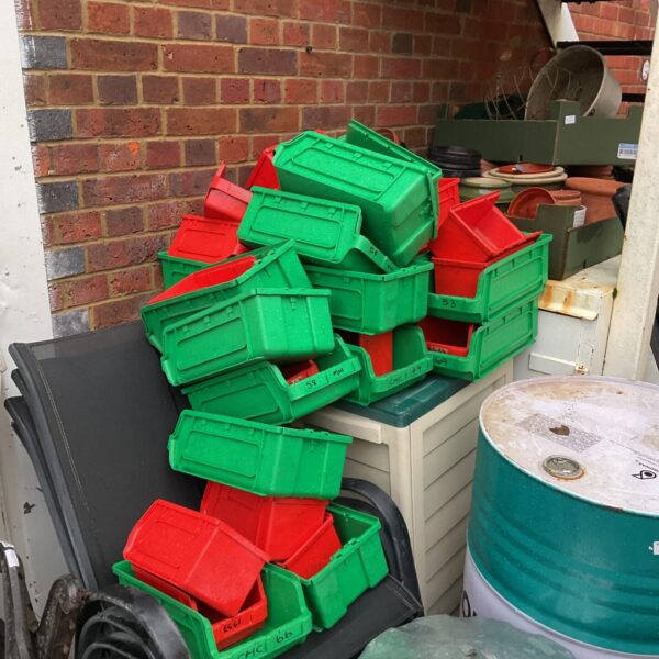 Large wall racking system with red and green storage tubs.