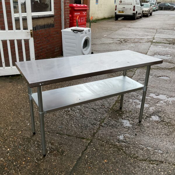 Stainless steel chef's prep table with lower shelf in a kitchen setting.