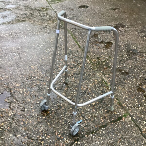 Silver adjustable height Zimmer frame walking aid for mobility.