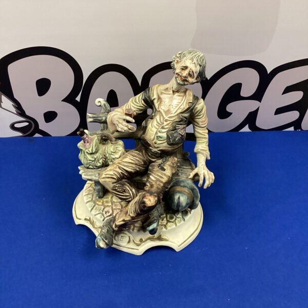 Vintage Italian porcelain figurine of a man on a bench.