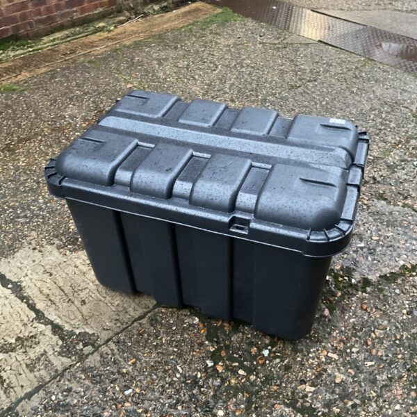 Large plastic storage box with wheels for outdoor storage.