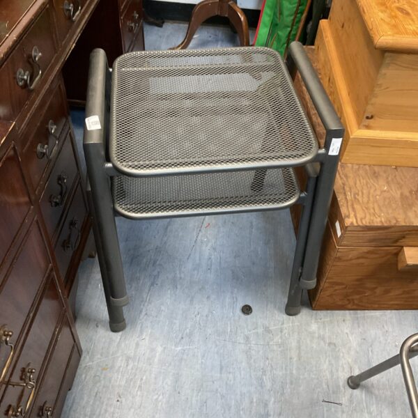 Black metal side table with mesh top and folding legs.