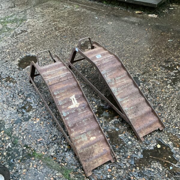 Rusted vintage car ramps for vehicle maintenance.