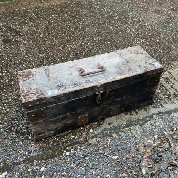 Front view of a vintage wooden trunk with metal clasp.