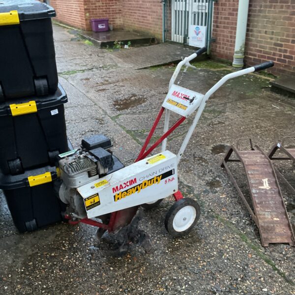 Red Macim rotovator for garden soil cultivation.