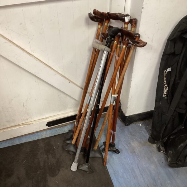 A lot of vintage wooden walking sticks displayed indoors.