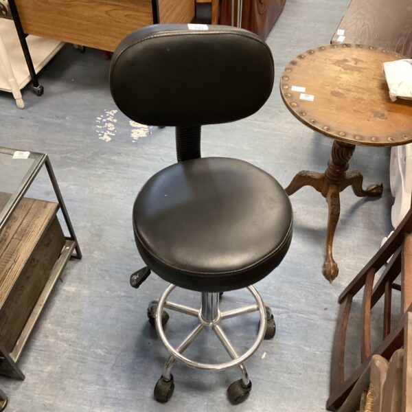 Black leather swivel stool with chrome base and casters.