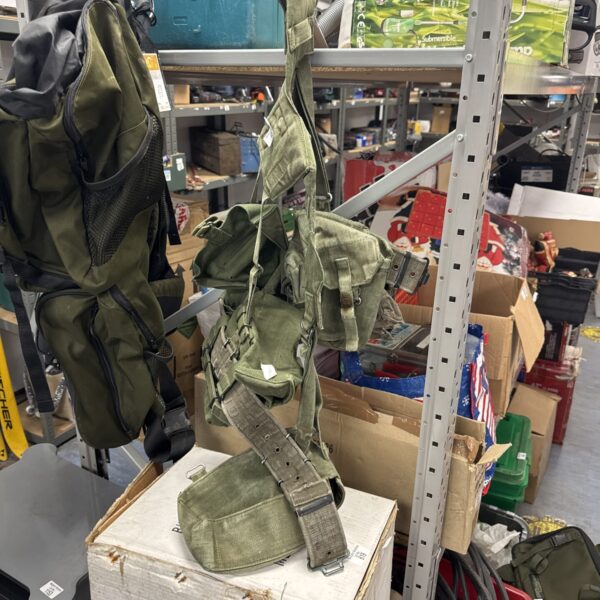 Green military webbing system with multiple pouches and straps.