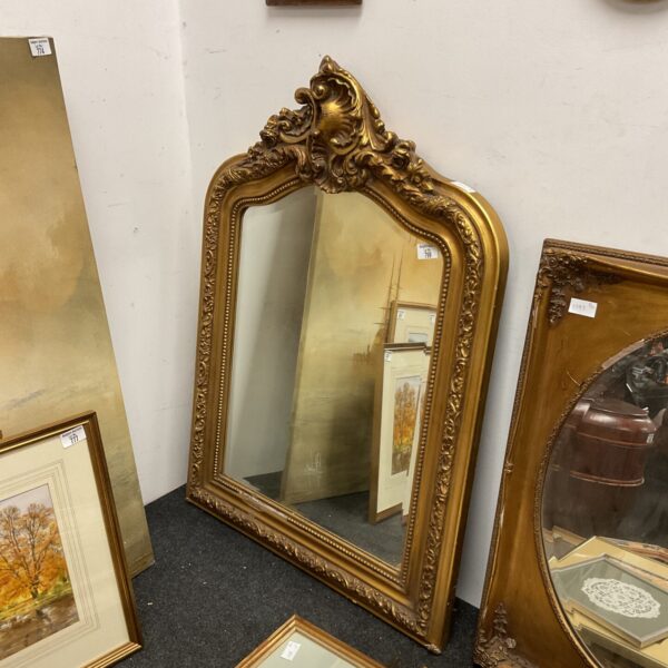 Ornate antique French style gilt mirror with detailed frame.