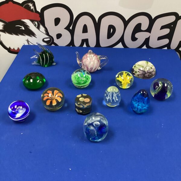 Vibrant glass paperweights displayed on a patterned surface.