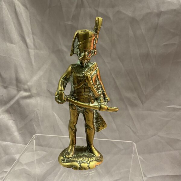 Vintage brass Napoleonic hussar figurine on clear stand.
