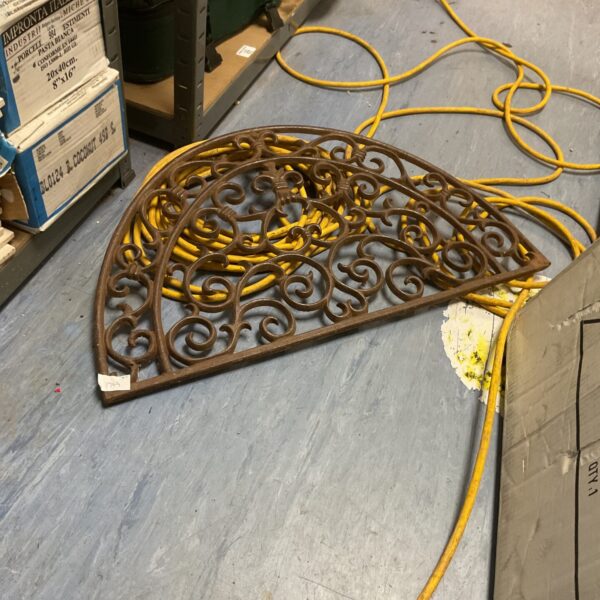 Intricate antique cast iron ornament with floral design.