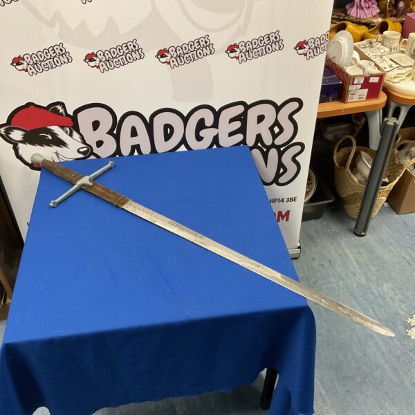 Large fantasy sword displayed on a blue table.