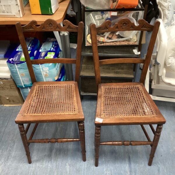 Pair of vintage spindle leg chairs with woven seats.